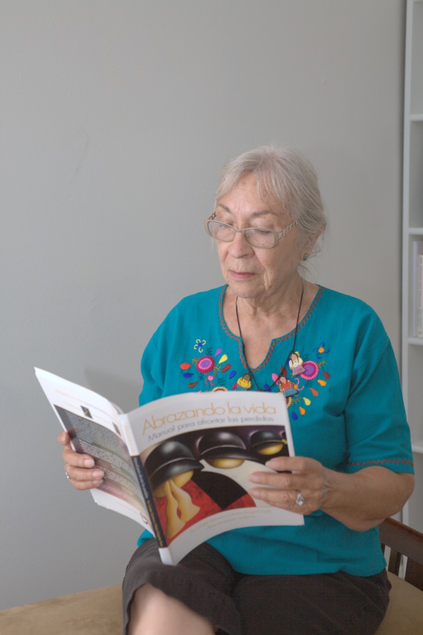 A woman holding and reading the Embracing Life journal